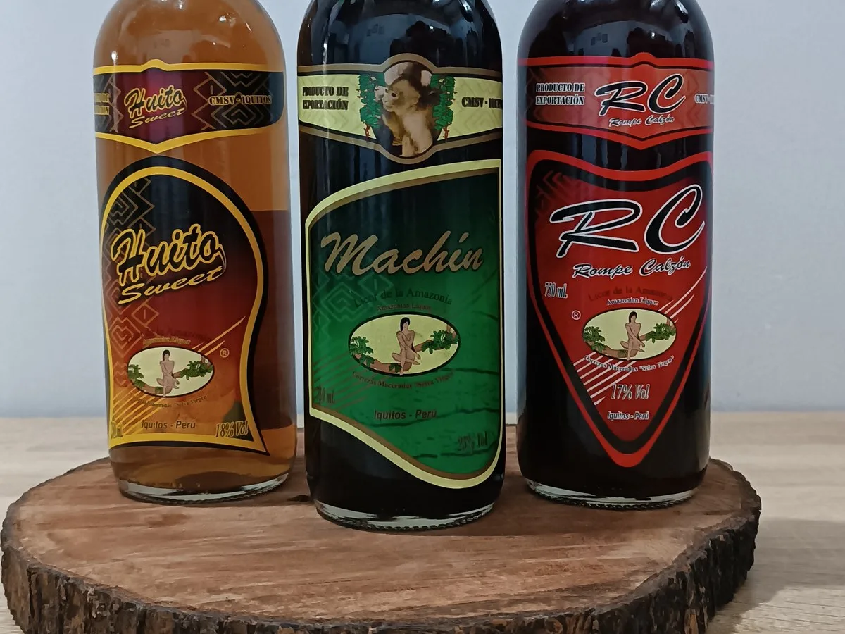 HuitoSweet, Machín y RC Rompe Calzón, licores artesanales de Iquitos, sobre un tronco de madera
