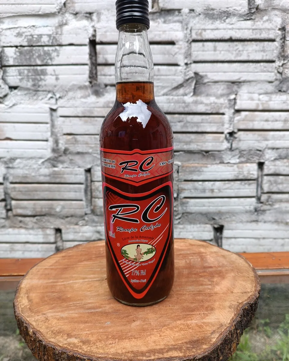 Botella de 750 ml de RC Rompe Calzón sobre un tronco de madera